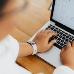 Person typing on laptop with email showing and AI symbol