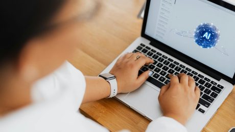 AI and Phishing Person typing on laptop with email showing and AI symbol